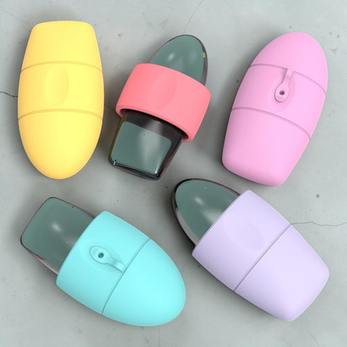 Five capsule-shaped cosmetic containers in pastel colors are arranged on a light gray surface. The containers include yellow, coral pink, light pink, light blue, and lavender, with one open container showing a dark gray product inside.