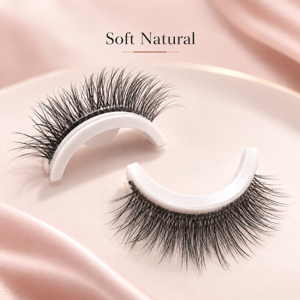 A pair of false eyelashes displayed on white curved holders, set against a soft pink satin background with the text 'Soft Natural' above.